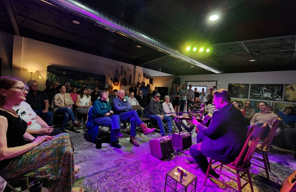 Musicians perform in a small, dimly lit art studio.